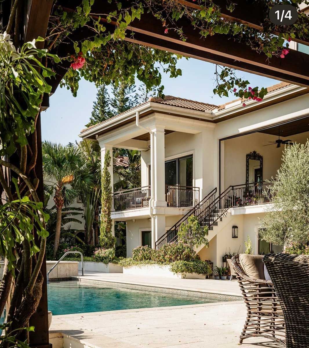 A large white house with a swimming pool in front of it