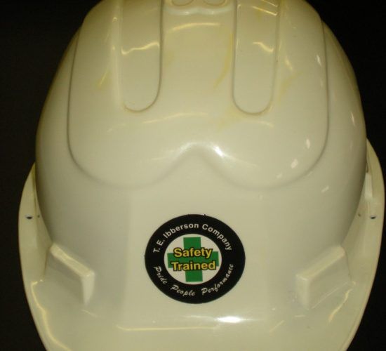 White hard hat with a company logo that reads 