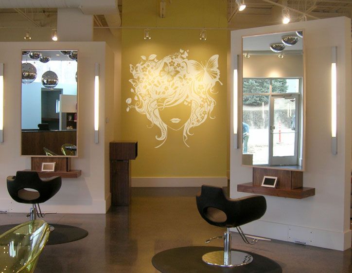 Hair salon interior with styling stations and a mural on the back wall.