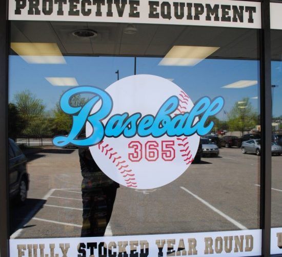 Baseball 365 store window with a baseball logo; light blue script over a white ball, 