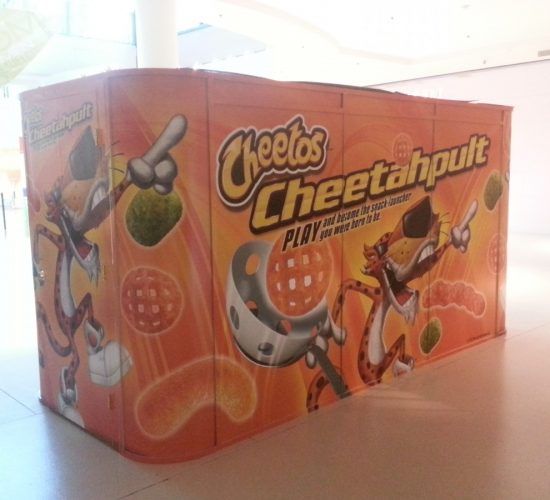 Cheetos Cheetahlpult display featuring Chester Cheetah aiming at snacks, orange and white.