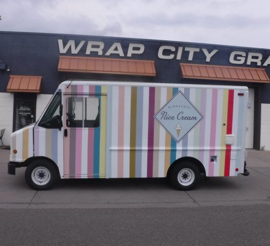 Ice cream truck with pastel stripes parked in front of Wrap City Graphics building.