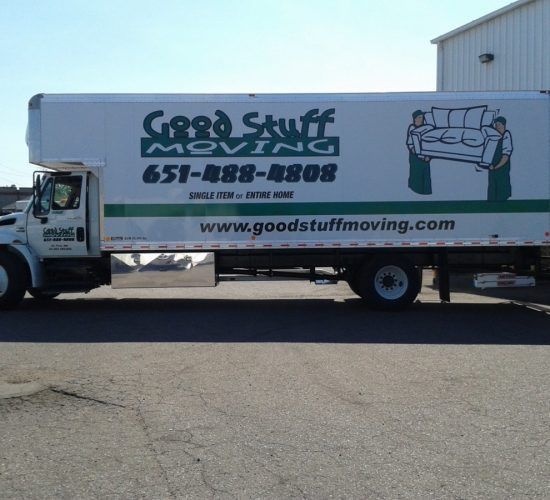 White Good Stuff Moving truck with logo on the side; a man is driving the truck.