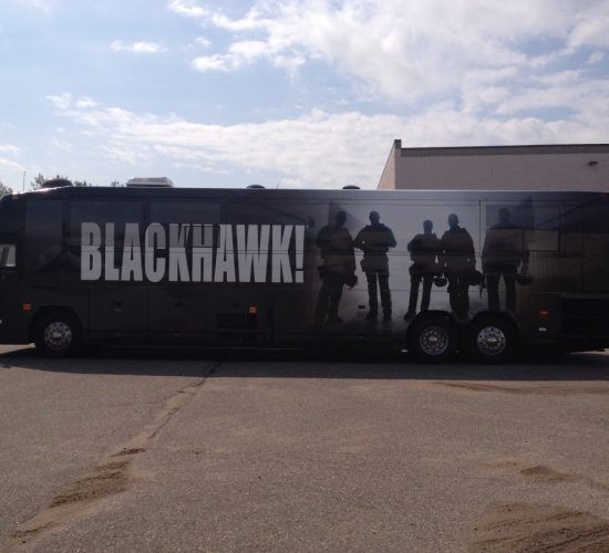Blackhawk team bus with black exterior, people silhouettes, and white text 