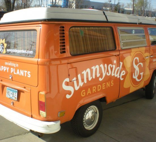Orange Sunnyside Gardens van with white lettering and logo.