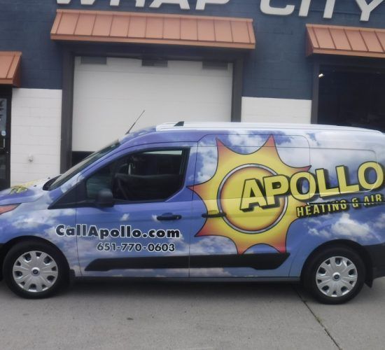Blue and white Apollo Heating & Air van parked outside a building, advertising its services.