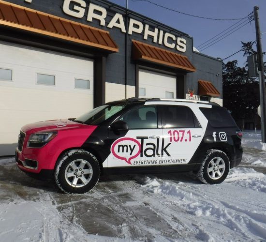 A vehicle wrapped in pink and black branding for 