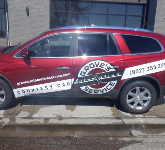 Red Buick SUV with Grove's Automotive Service logo on the side. Phone number on the side: (952) 353-2259.