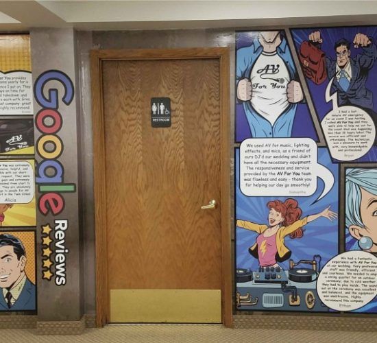 A wooden door with a restroom sign, surrounded by comic book-style murals, and a 