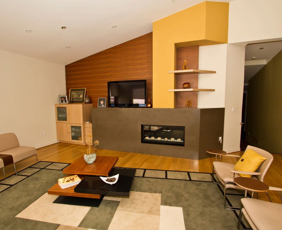 Living room with fireplace, TV, modern furniture, wood and painted accents, and area rug.