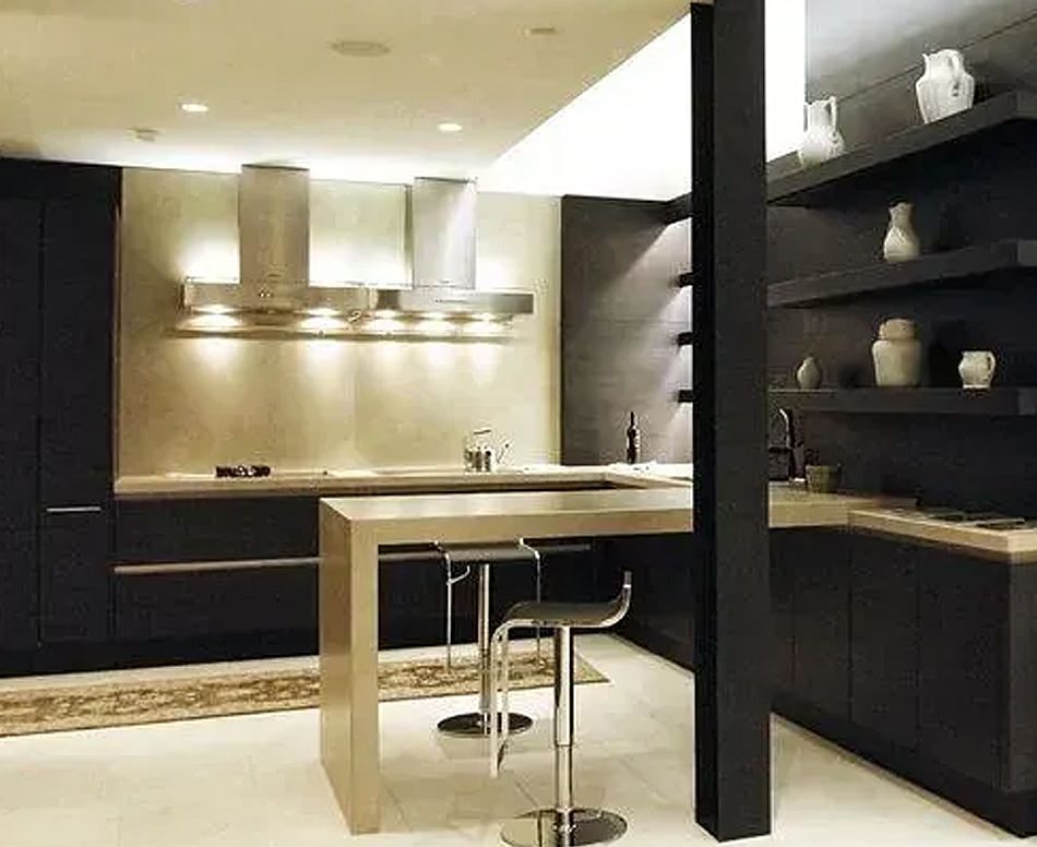 Modern kitchen with dark cabinets, stainless steel island with stools, and open shelves with decorative items.