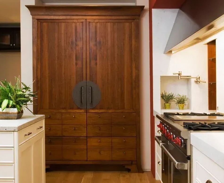 Wooden cabinet with drawers in a kitchen, next to a stove and counter.