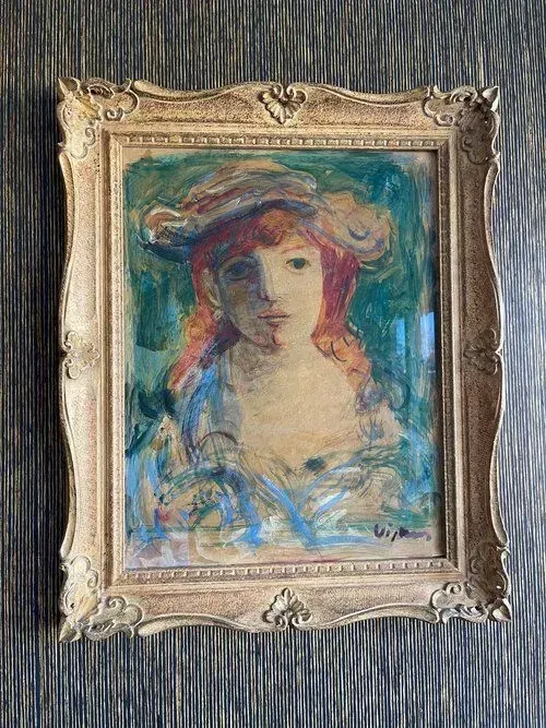 Painting of a woman in a hat. She has red hair and wears a blue dress. The painting is in an ornate gold frame.