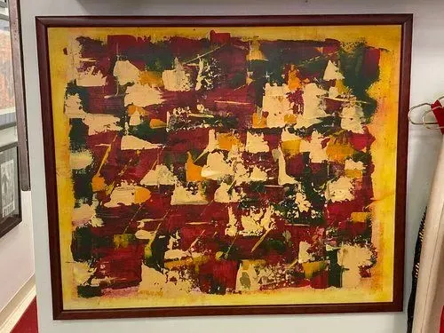Abstract painting with red, yellow, and green geometric shapes in a brown frame.