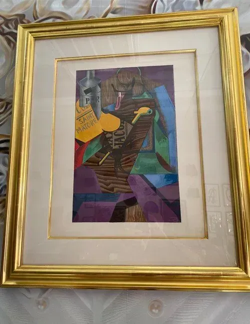 Abstract painting in a golden frame with bold colors including purple, brown, and yellow.