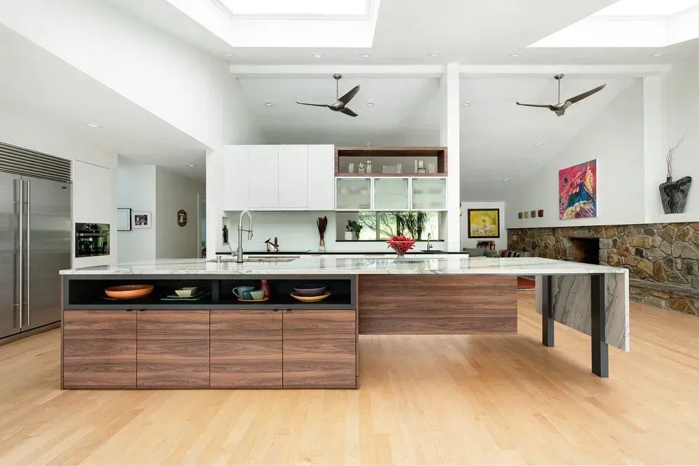 Modern kitchen with large island, wood cabinets, stainless steel appliances, and skylights.