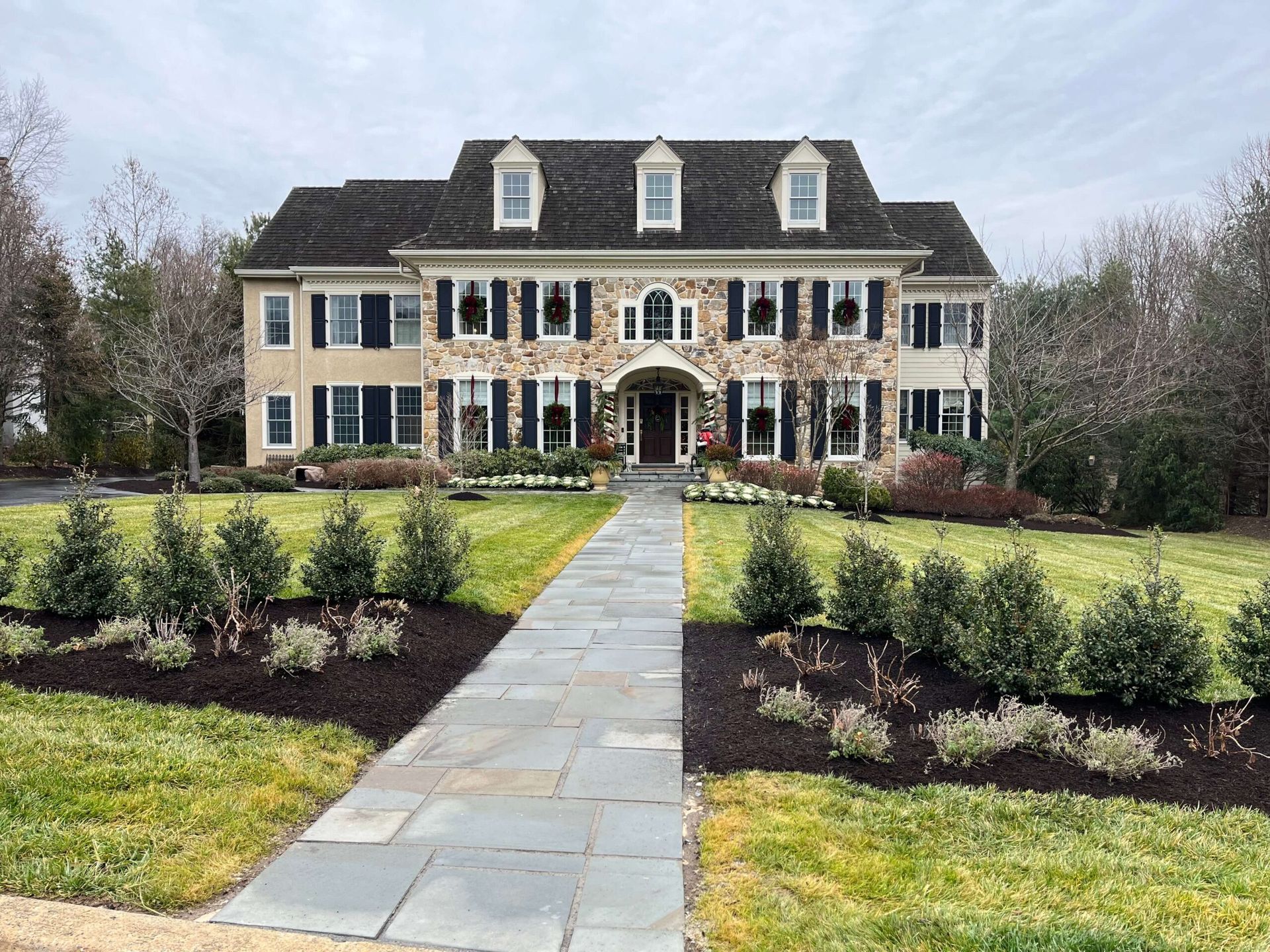 A large house with a stone walkway leading to it.