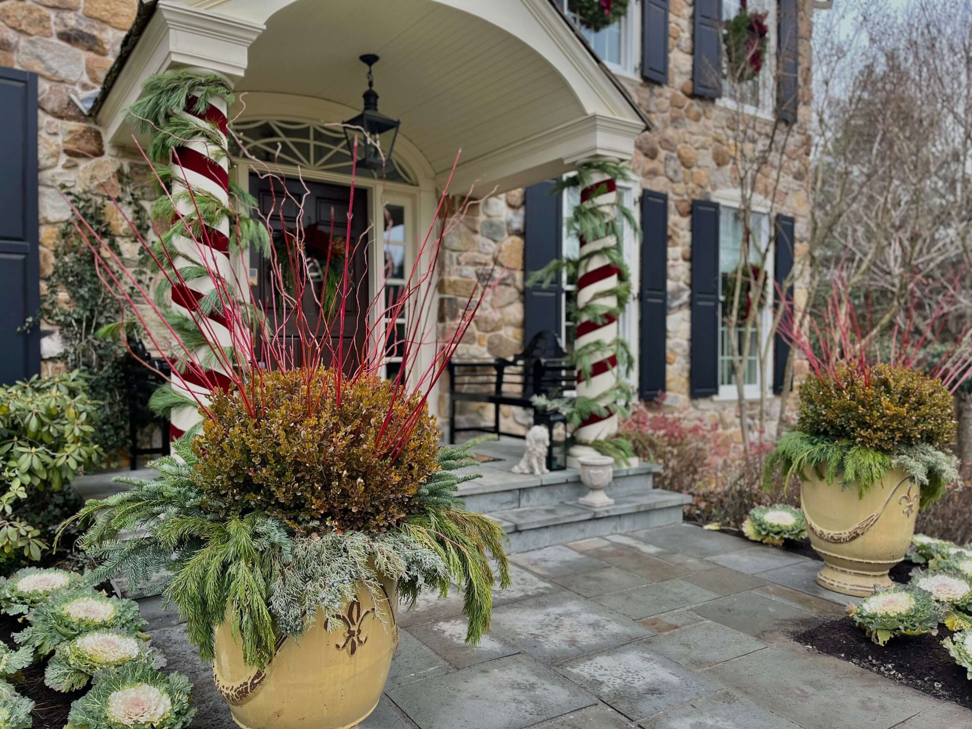 A stone house with a porch decorated for christmas