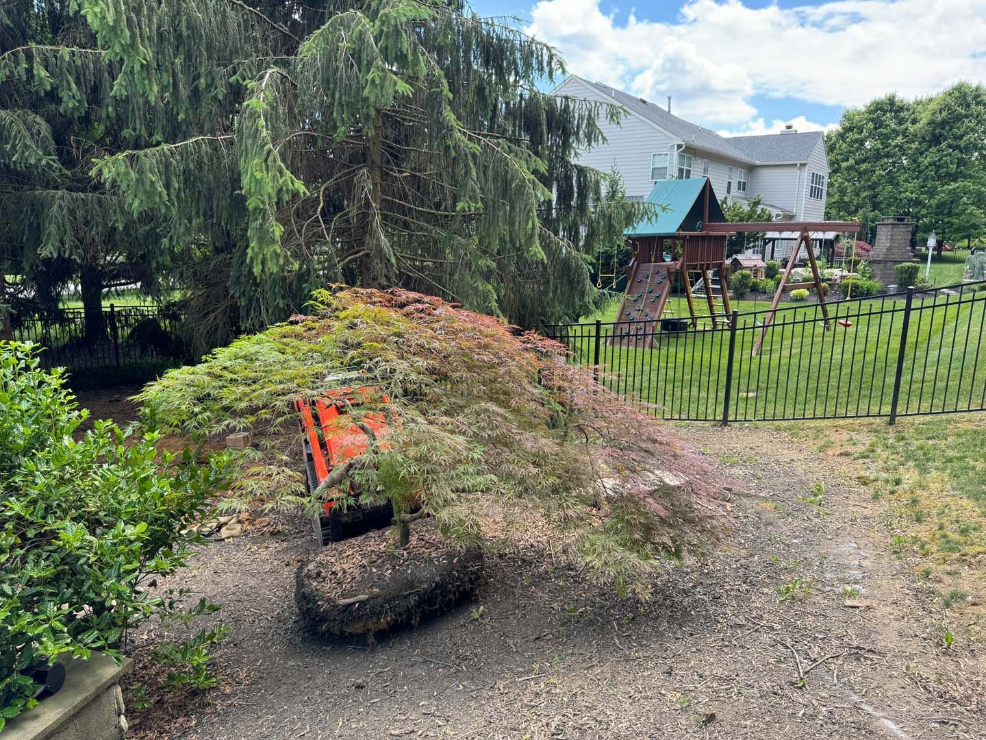 A large pile of dirt is sitting in the middle of a yard.