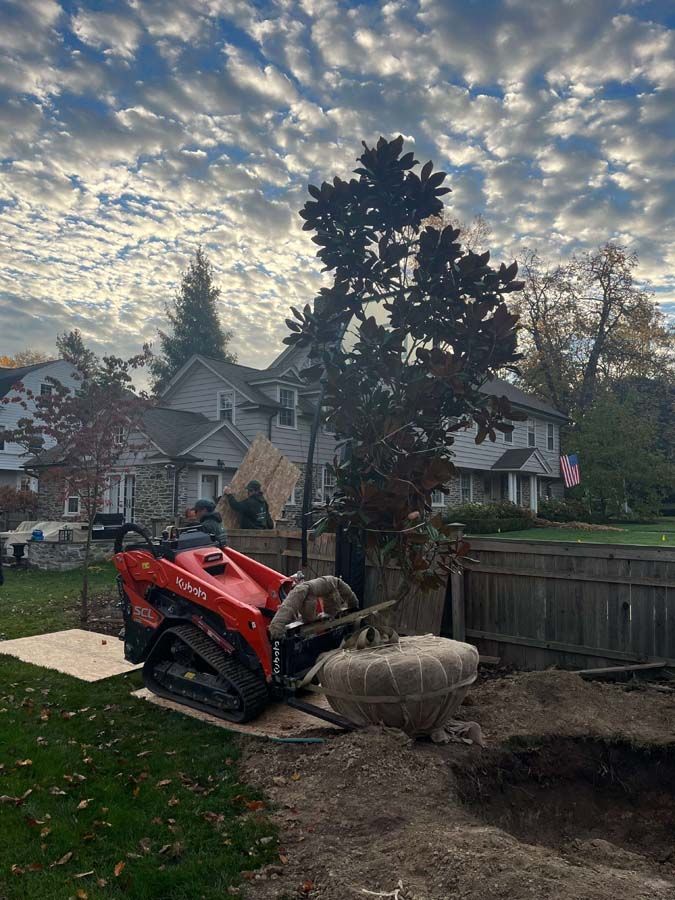 A red tractor is sitting on top of a pile of dirt in a backyard.