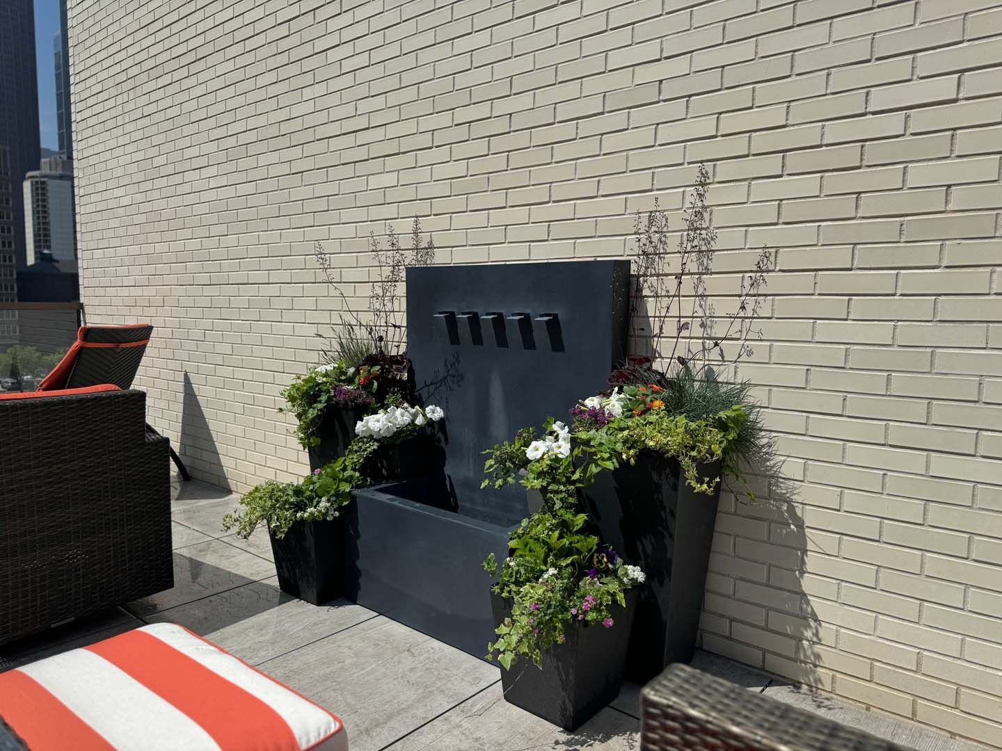 A brick wall with a fountain and planters on it