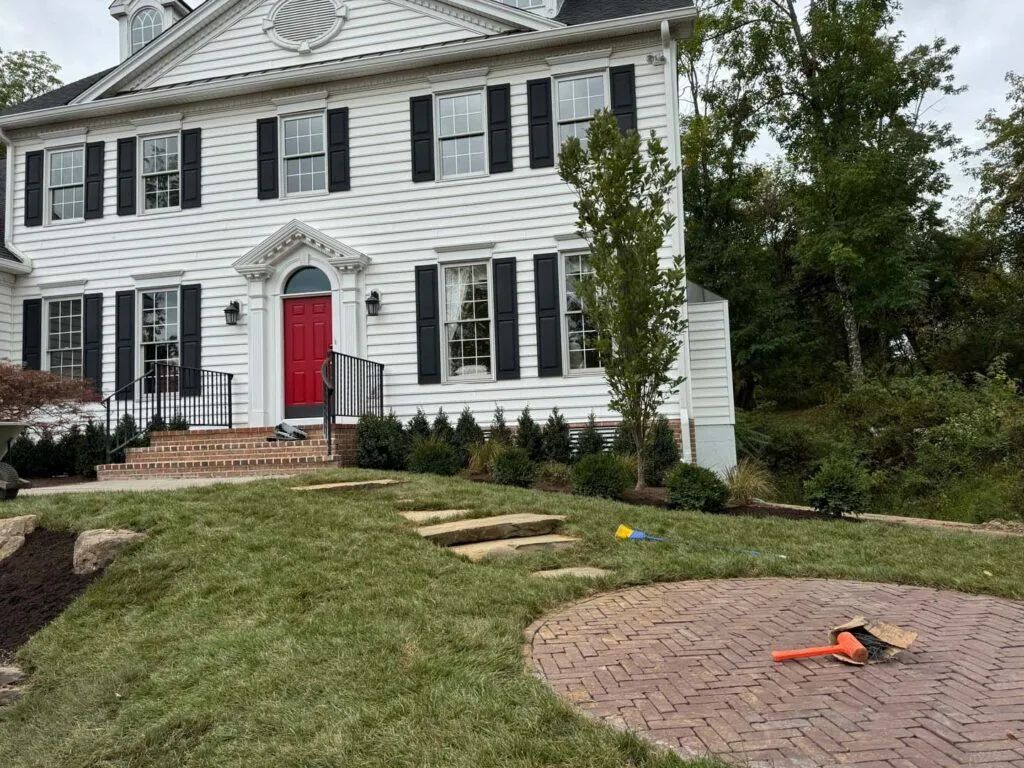 A large white house with a red door and black shutters.