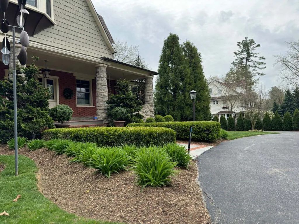 A house with a driveway and a windmill in front of it
