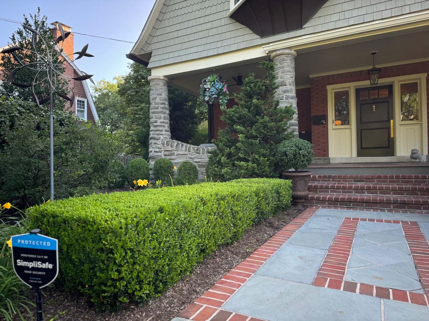 A house with a brick walkway and a sign in front of it