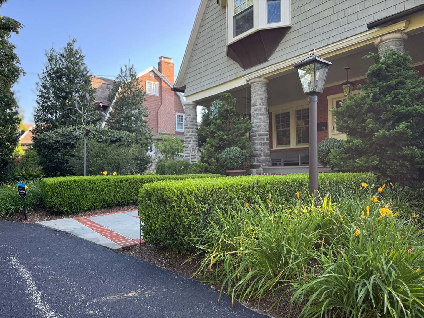 A house with a porch and a lamp post in front of it