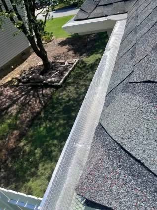 Gutter covered with mesh to prevent debris. It is located on the roof of a house.