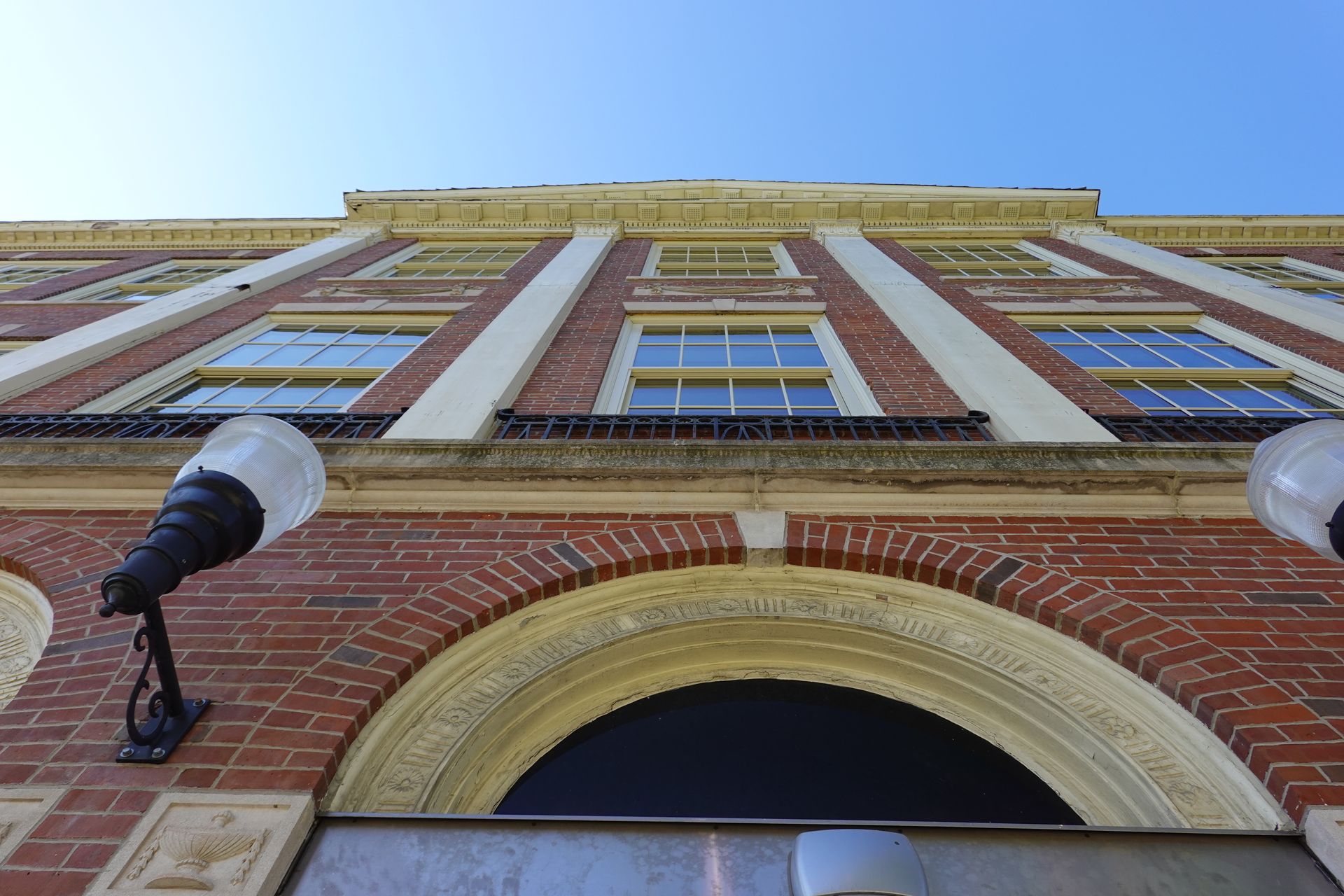 Looking up at a brick building with a blue sky in the background