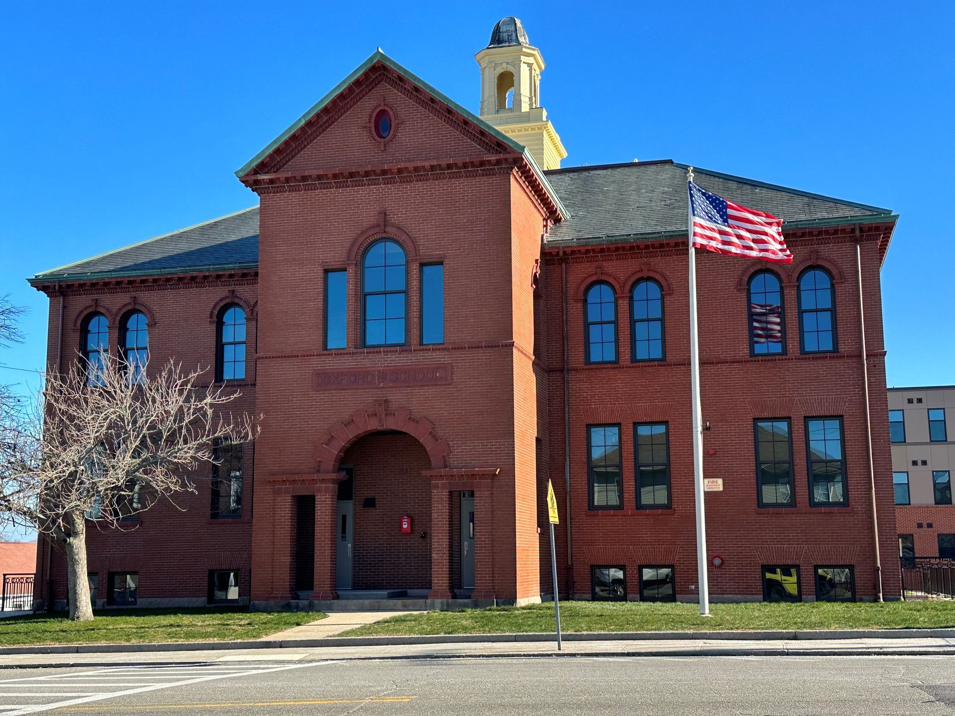 A large red brick building with an american flag in front of it