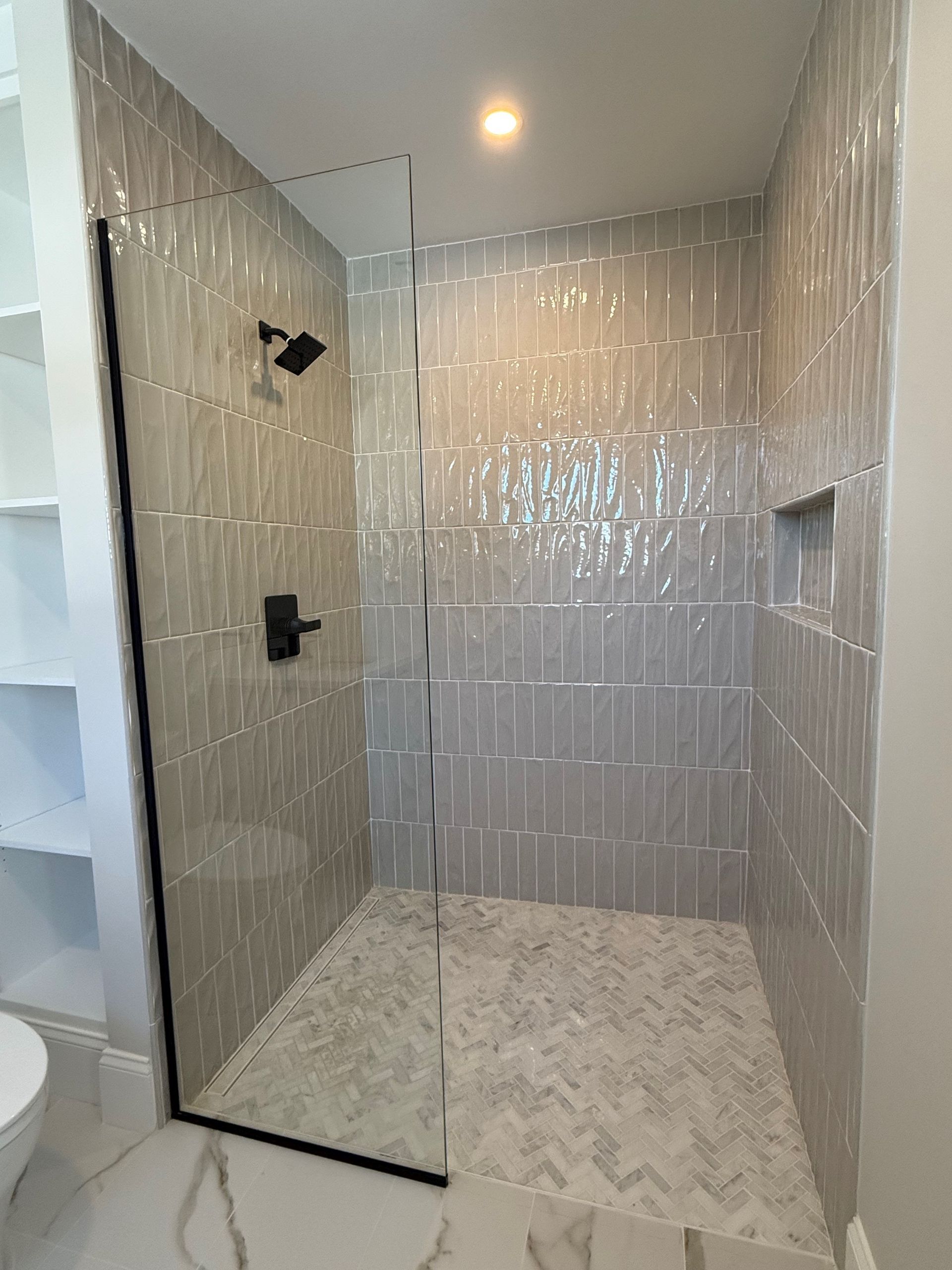 A bathroom with a walk in shower and a toilet.