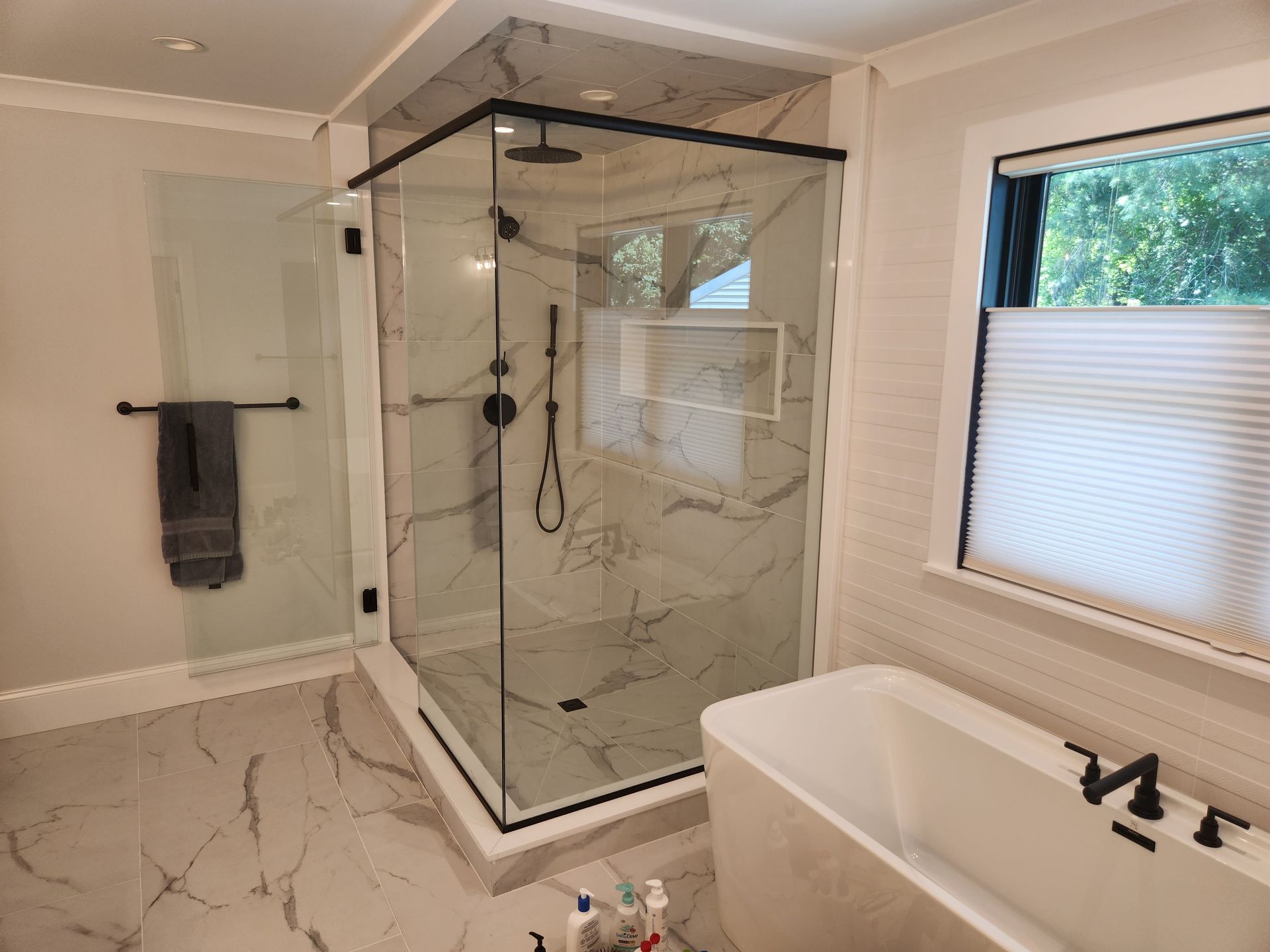 A bathroom with a walk in shower and a bathtub.