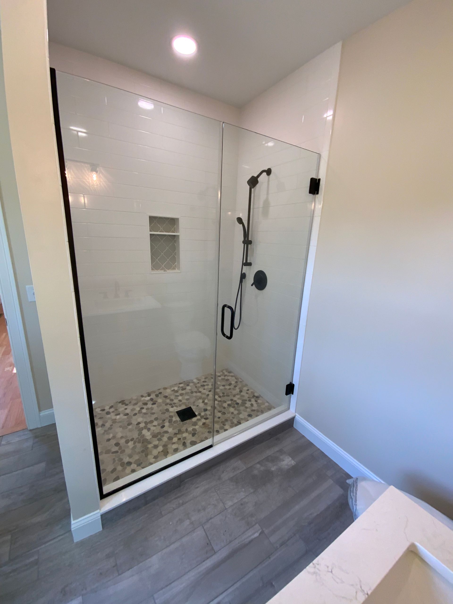 A bathroom with a walk in shower and a sink.