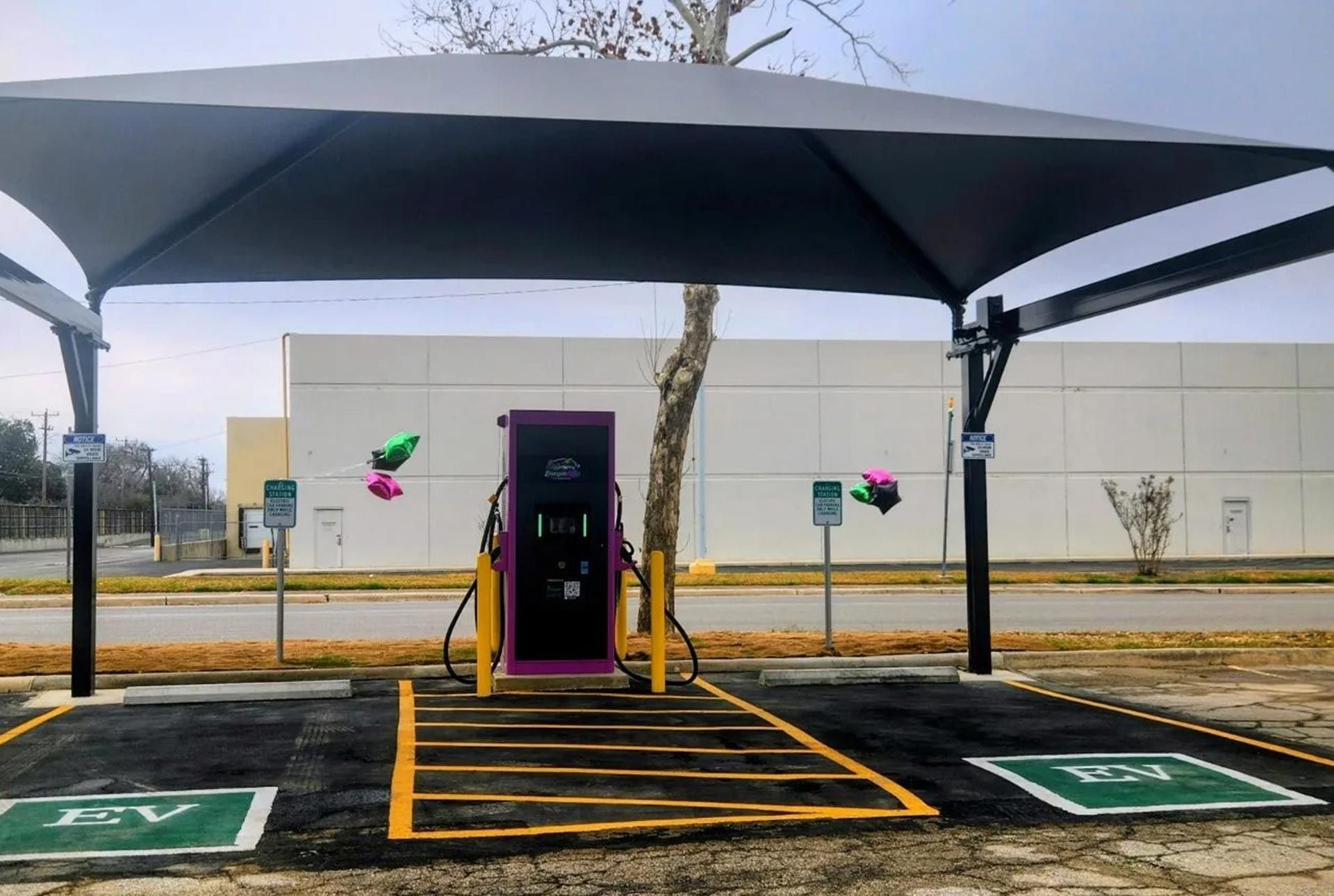 Electric car charging at a station in a parking lot.