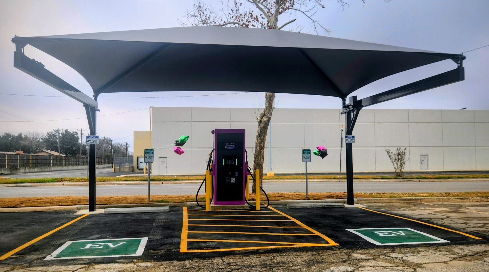 Covered EV charging station with two chargers under a large canopy in a parking lot