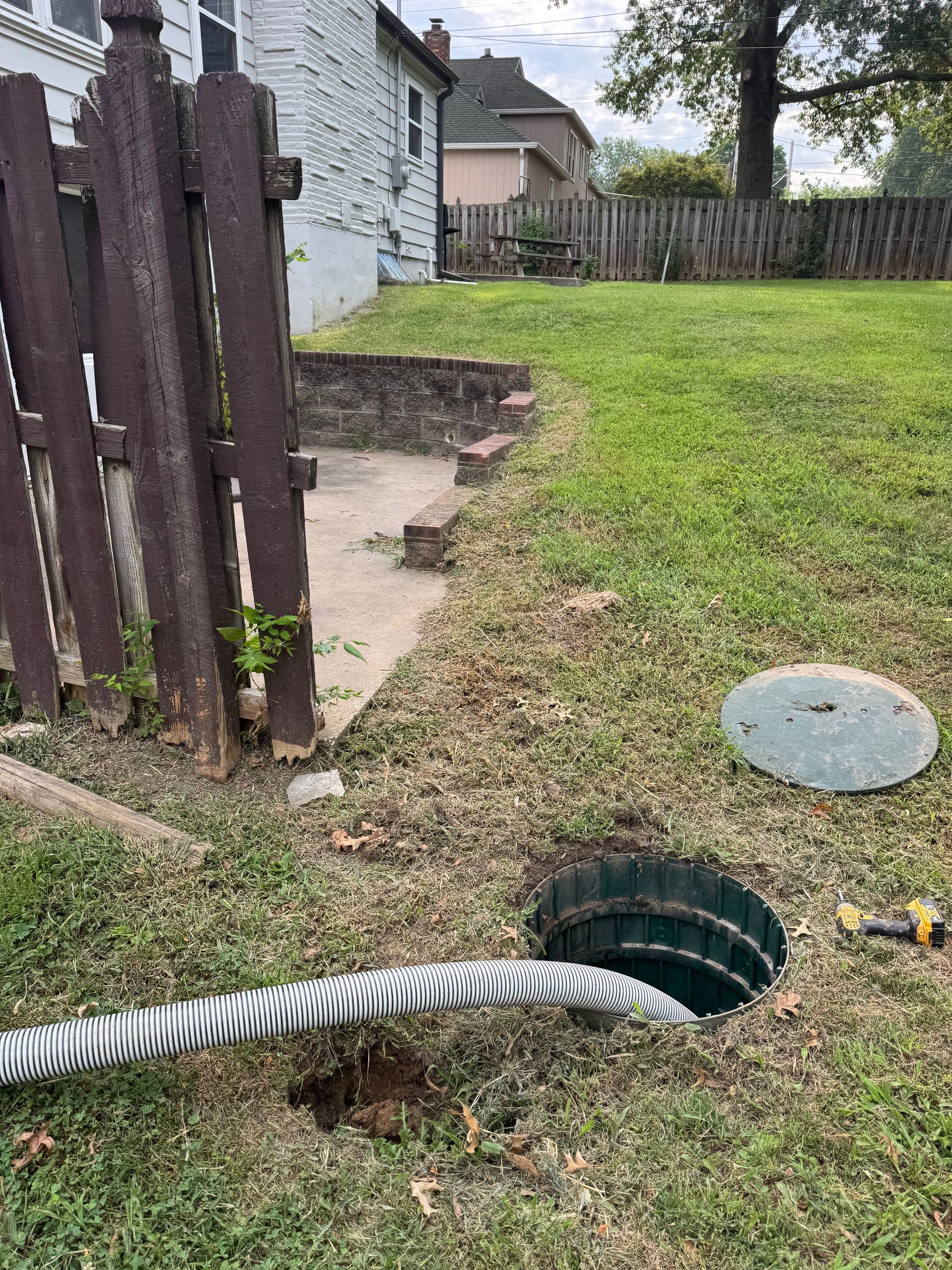 White septic tank truck with silver tank parked in front of a house.