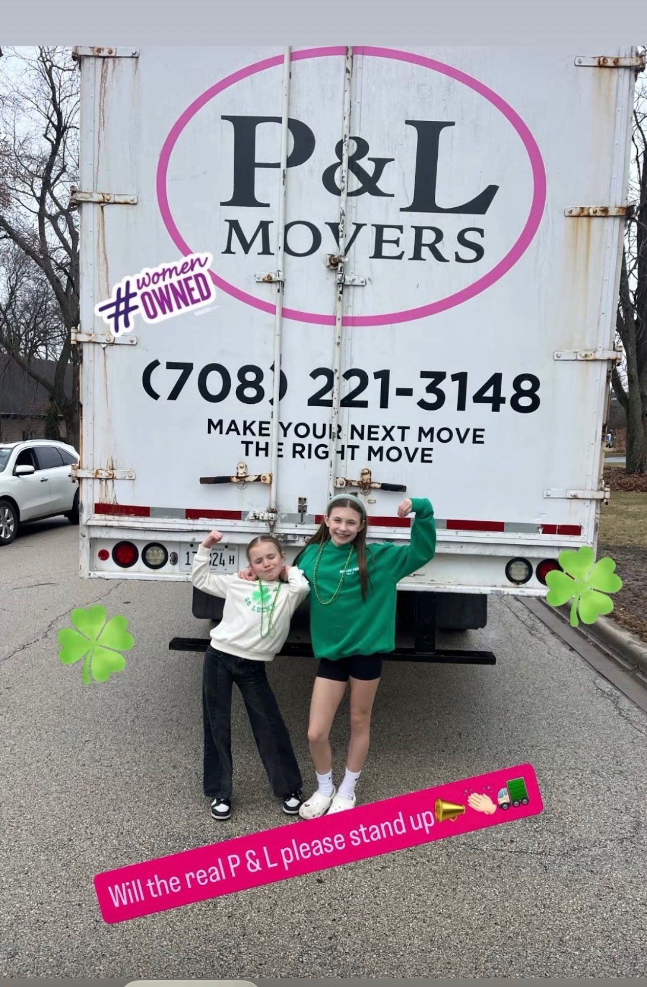 Two women posing in front of a P&L Movers truck with arms raised on a residential street
