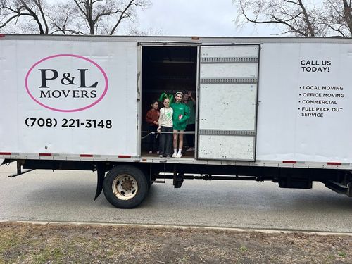 P&L Movers truck parked on a street with two people standing in the open cargo door