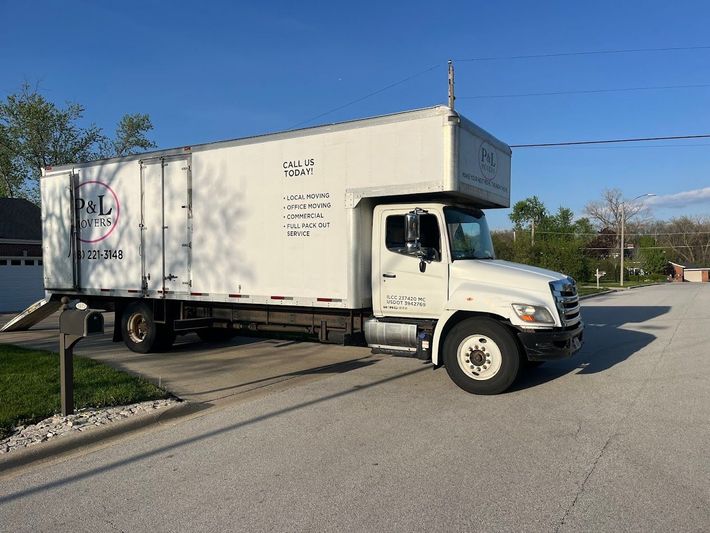 White box truck turning onto a road near a curb on a sunny day