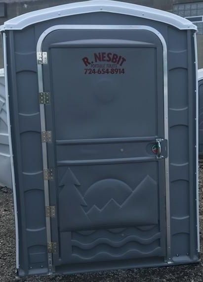 Gray portable toilet with white top. Door has mountain/wave design and business name/phone.