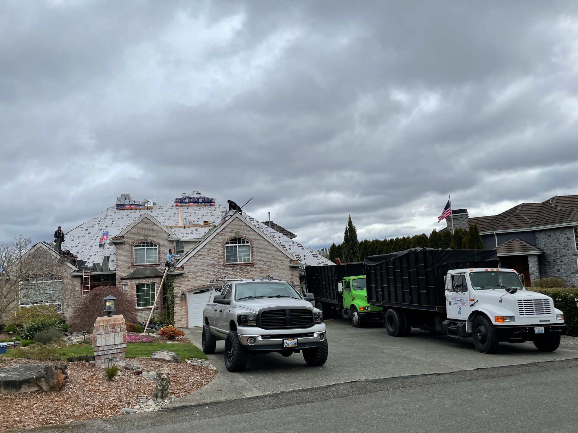 A group of trucks are parked in front of a house.