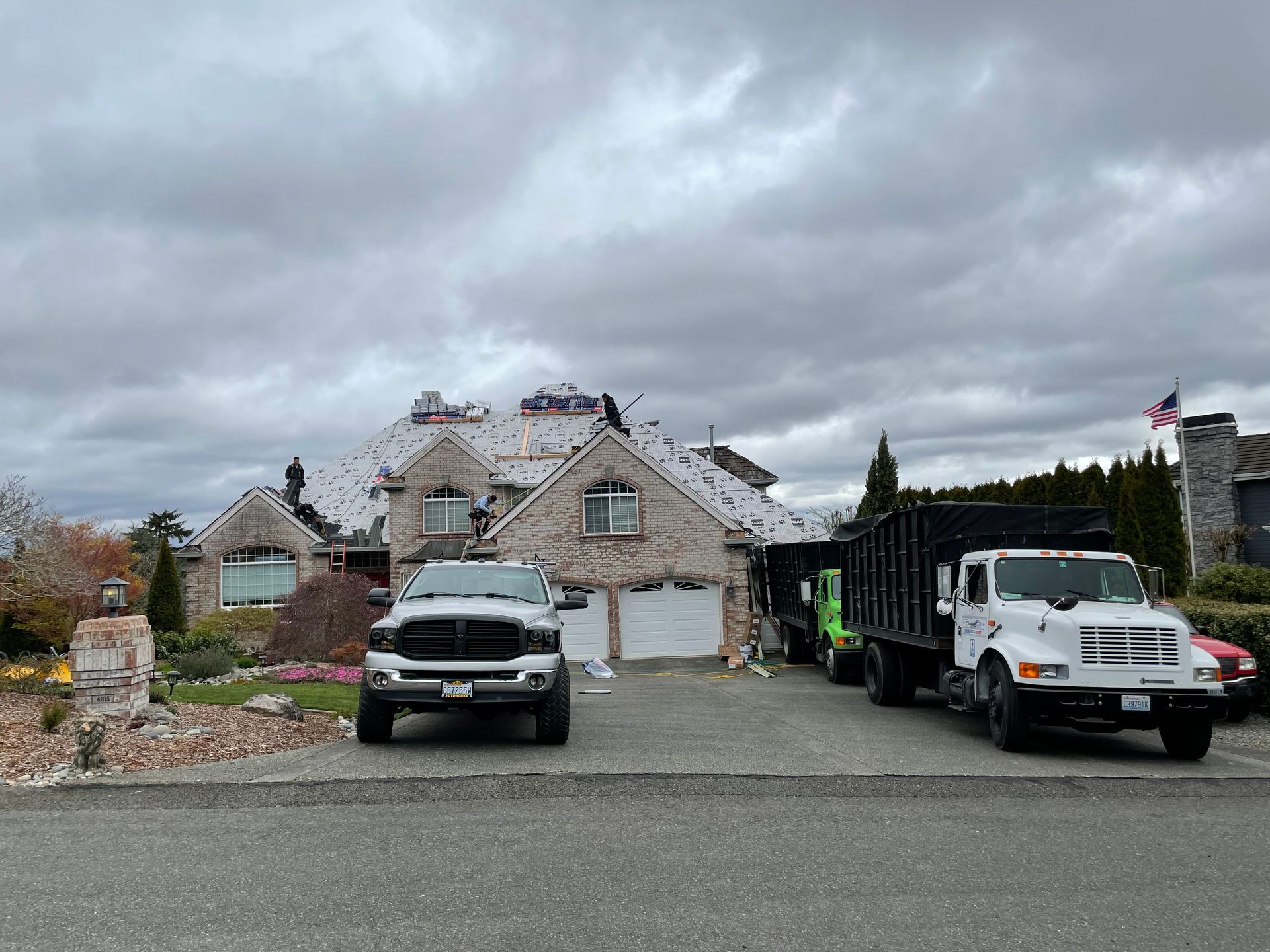 Two trucks are parked in front of a house.