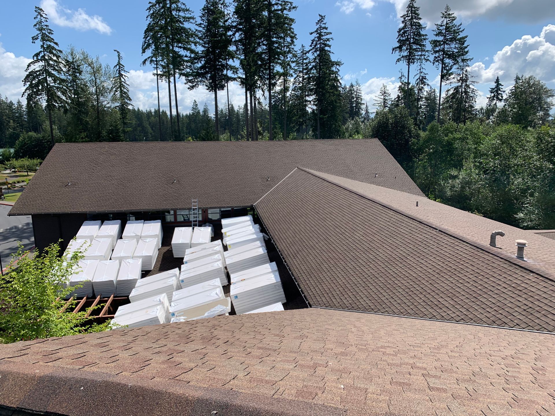 A roof with a lot of boxes on it and trees in the background