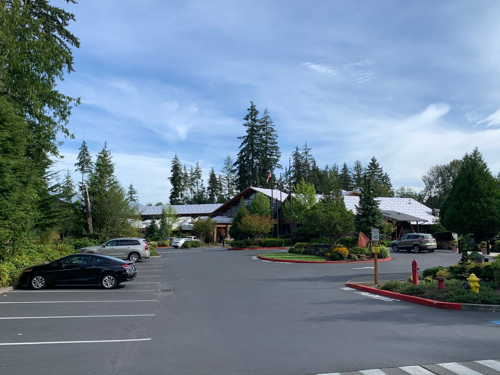 A parking lot with cars parked in front of a building.