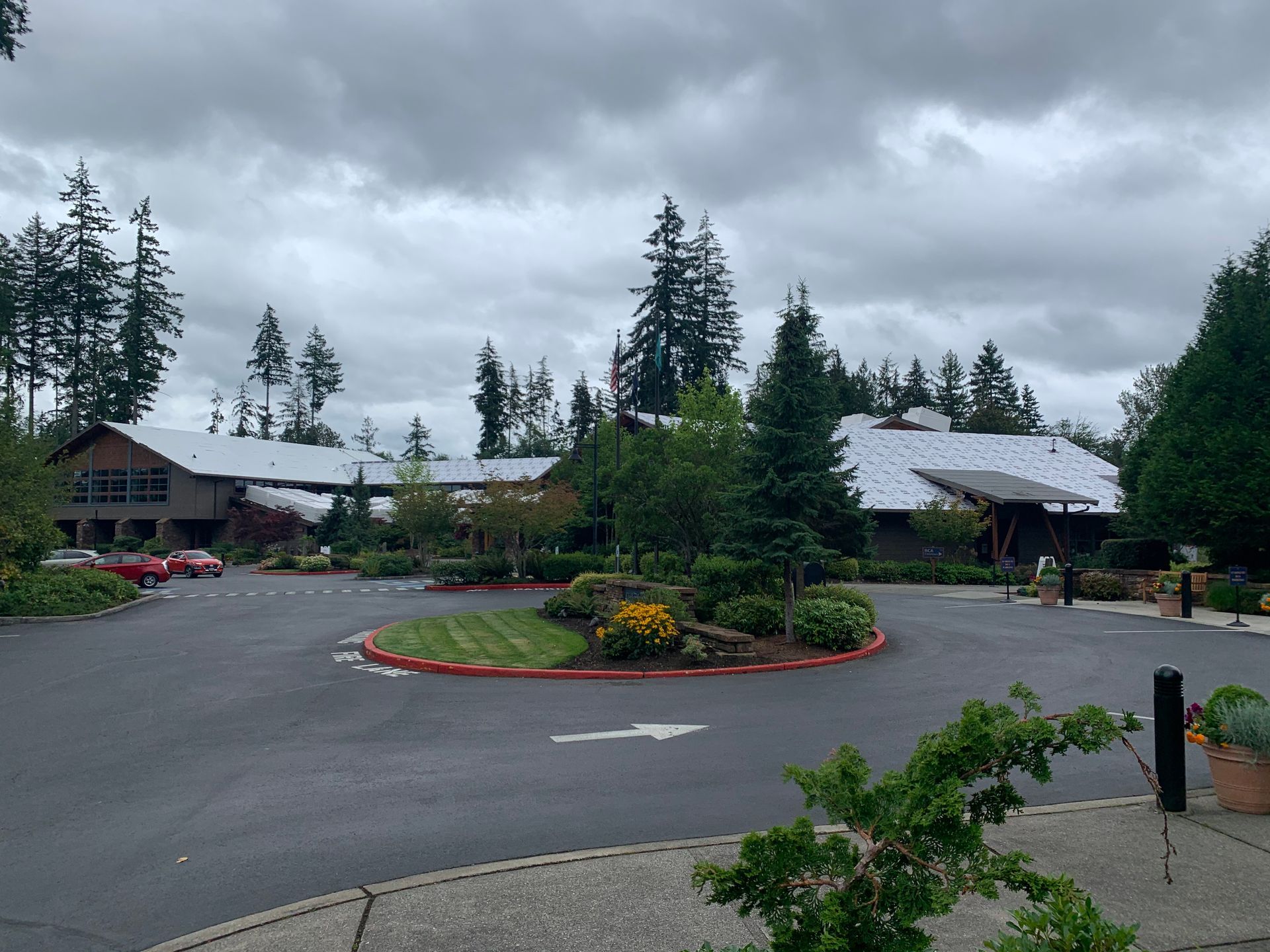 A parking lot in front of a building with trees in the background