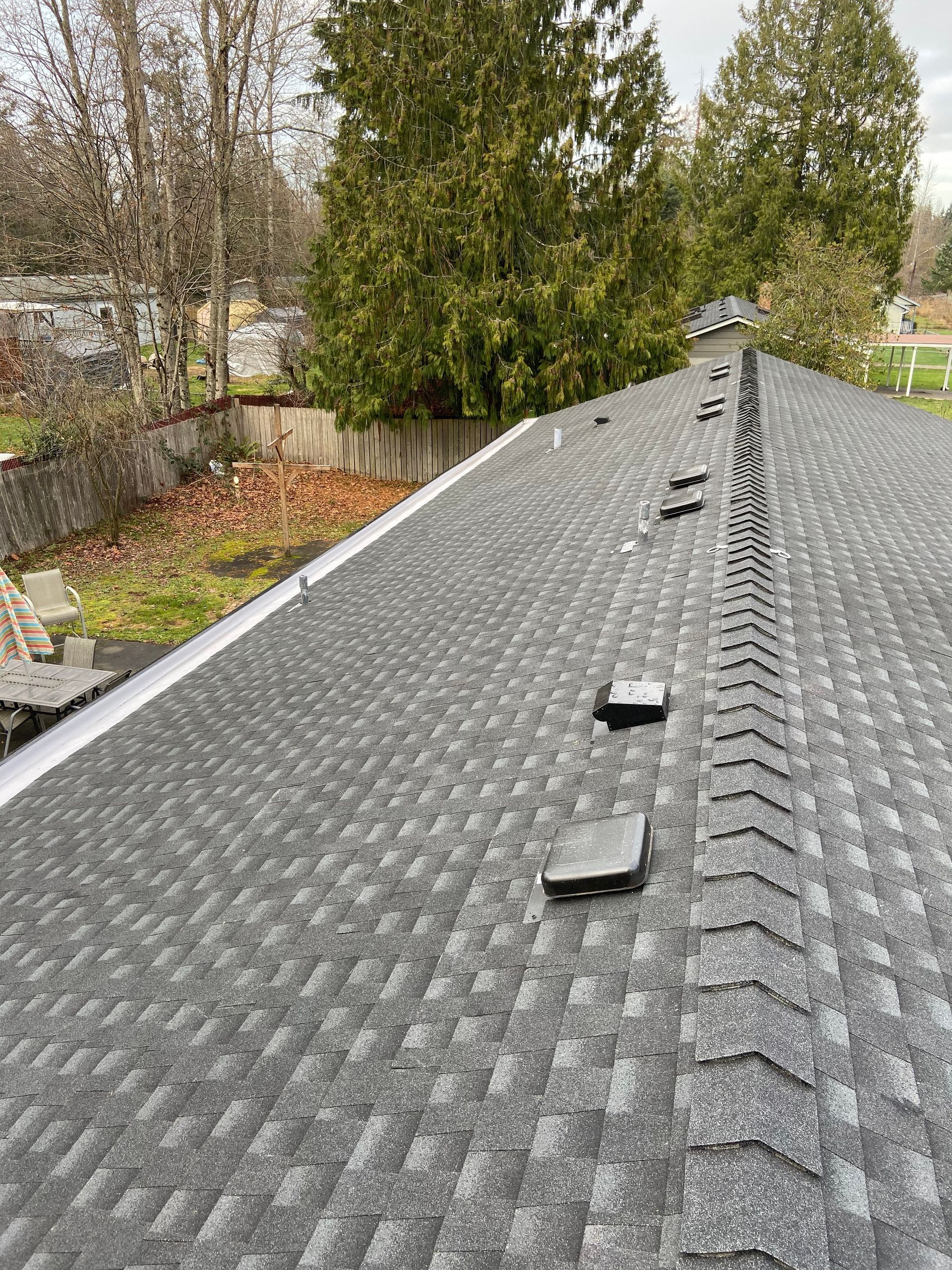 A roof with a lot of vents on it and trees in the background.