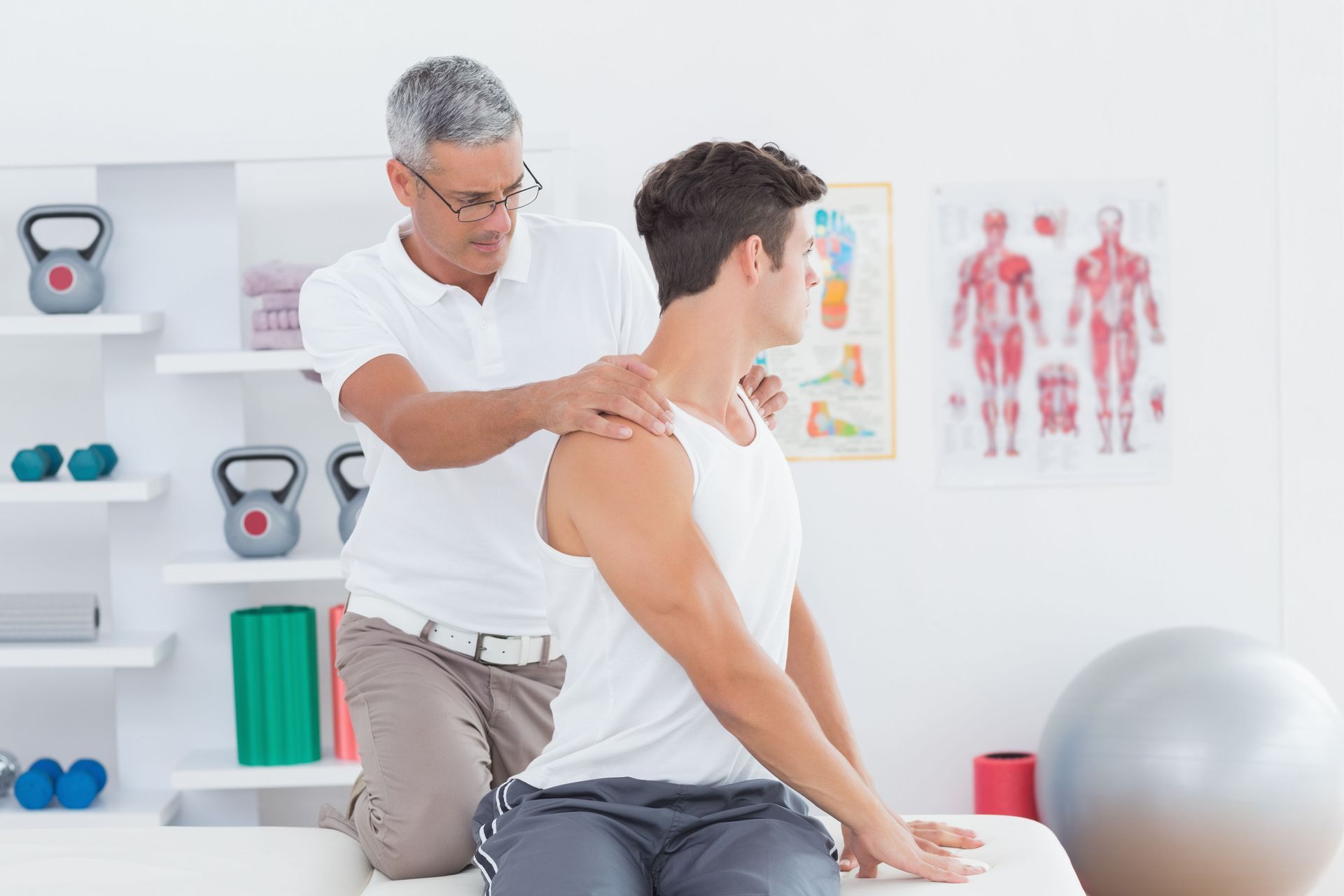Physiotherapist assisting a patient with a neck rotation in a clinic setting.