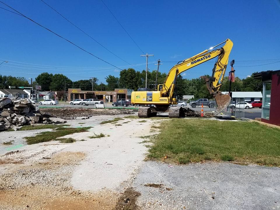 A yellow excavator is working on a construction site.